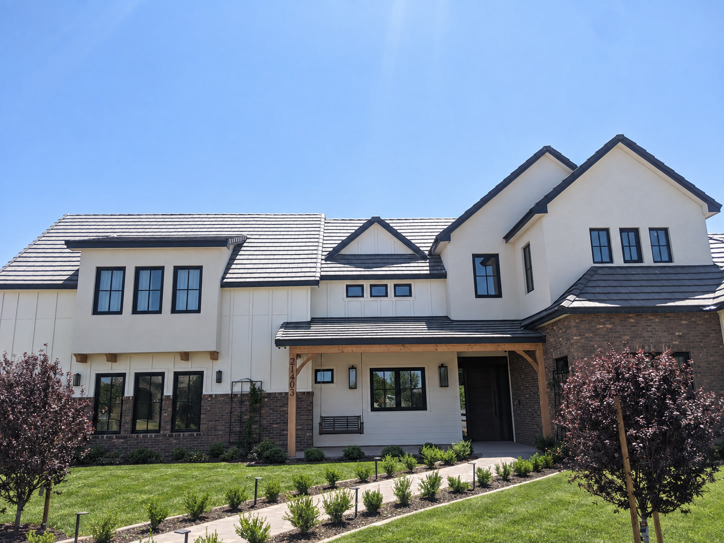 Two-story neo-eclectic Mediterranean suburban home with stucco, tile roof, and arched entry